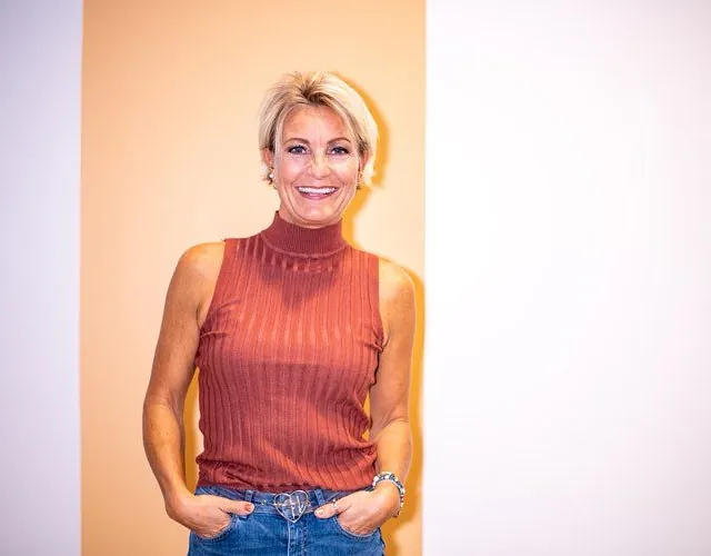 Smilende dame i ferskenfarget genser